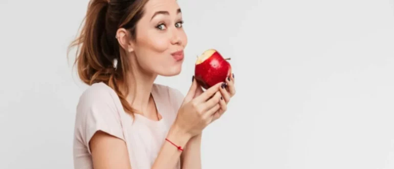 Mujer comiendo manzana roja