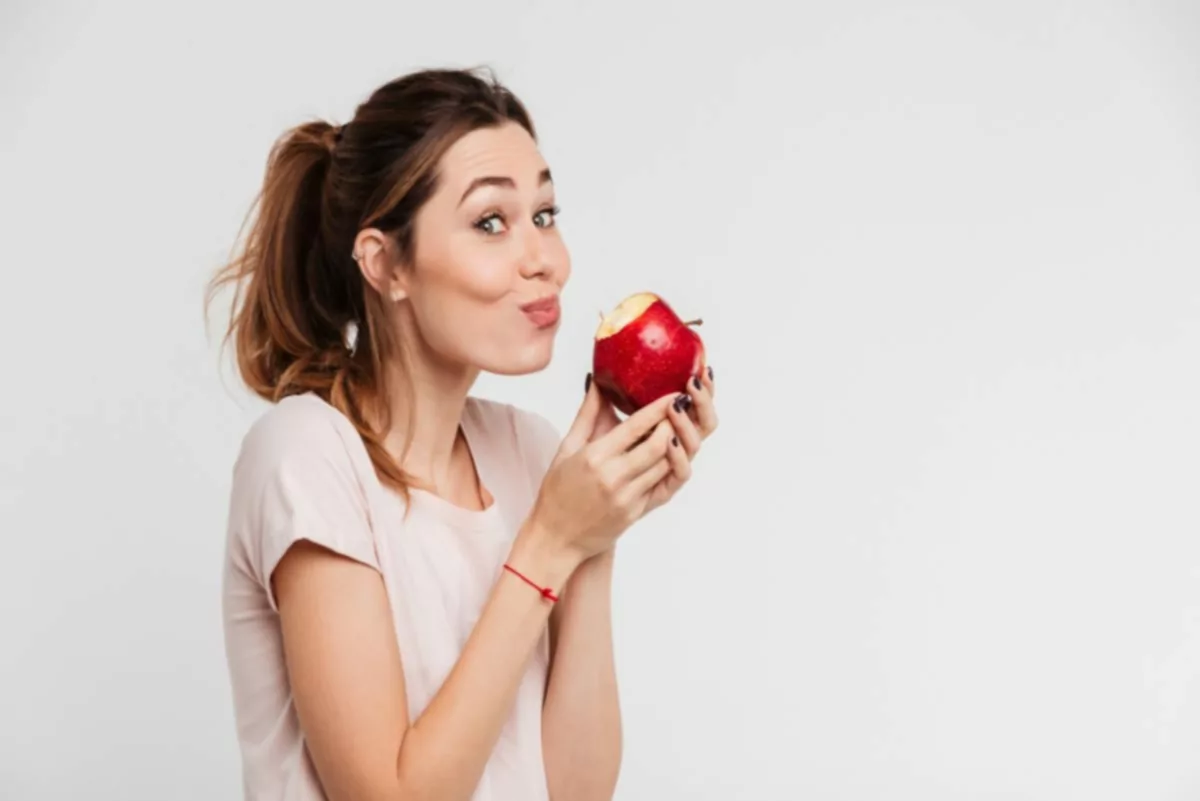 Mujer comiendo manzana roja