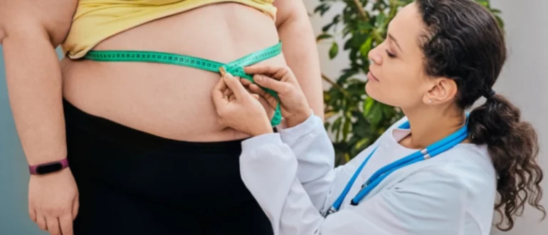 Nutricionista inspeccionando la cintura de una mujer con una cinta métrica para prescribir una dieta de adelgazamiento