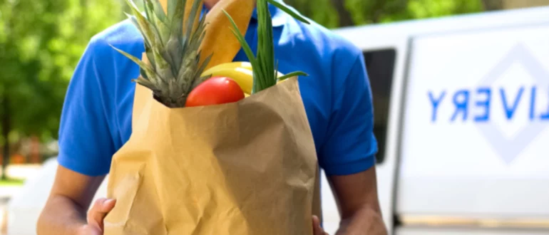 repartidor de comestibles sosteniendo la bolsa de la compra