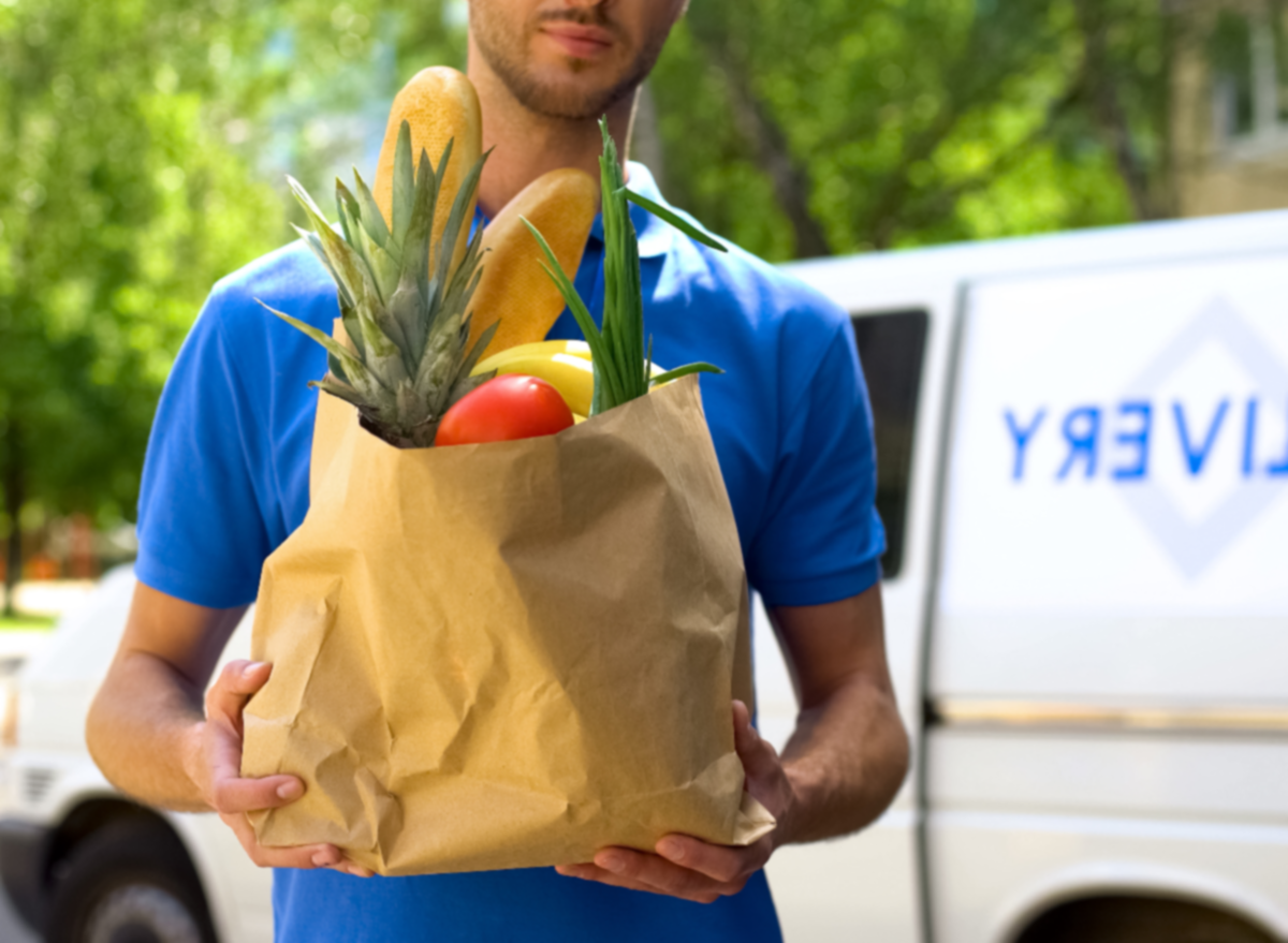 repartidor de comestibles sosteniendo la bolsa de la compra