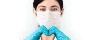 médico con mascarilla y bata azul de pie corporativa en el concepto de trabajo de la salud