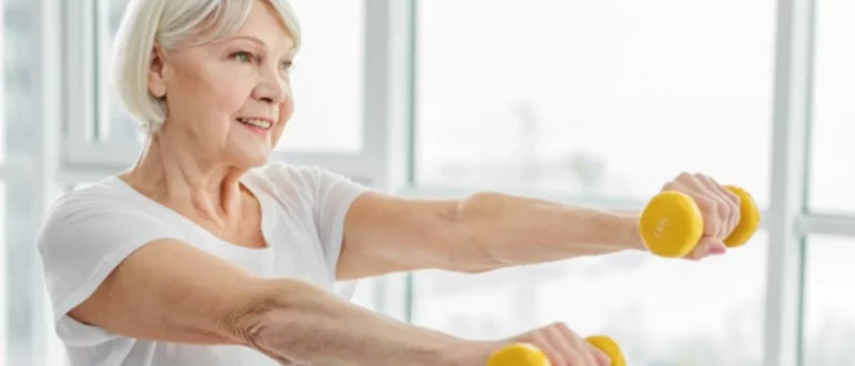 mujer madura feliz realizando ejercicios con mancuernas para vivir hasta los 100 años y más