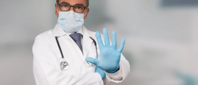 Doctor,con,cara,médica,máscara,y,guantes,médicos,muestra,parada