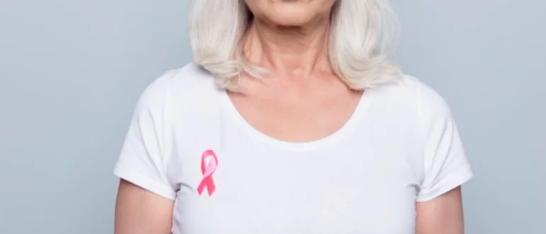 mujer con camiseta blanca y lazo rosa contra el cáncer de mama