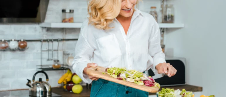 mujer madura cocina saludable en la cocina brillante, concepto de las mejores dietas de pérdida de peso de 2023