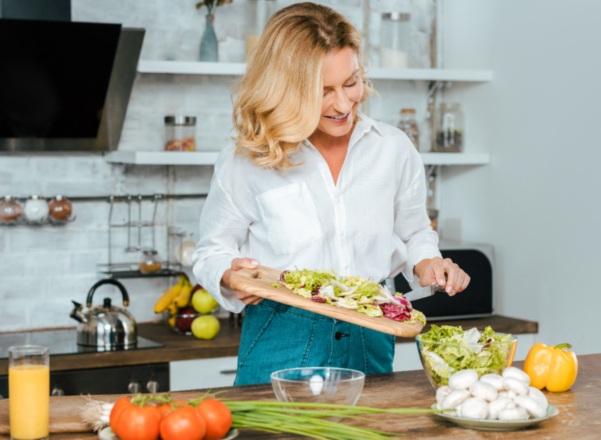 mujer madura cocina saludable en la cocina brillante, concepto de las mejores dietas de pérdida de peso de 2023